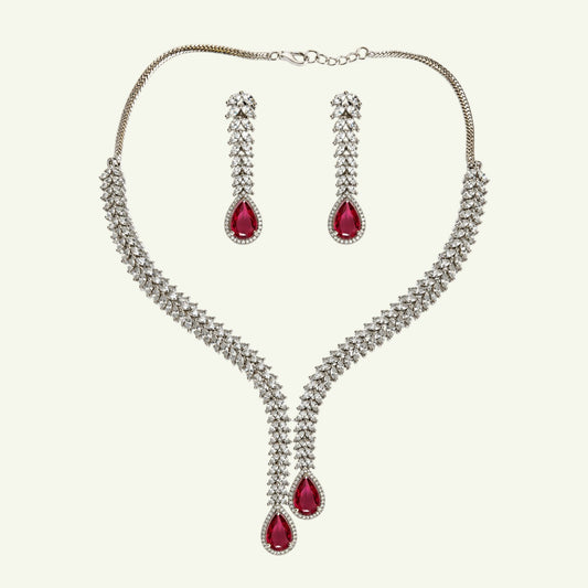 Anzora Jewel Alcyone necklace and earring set with clear crystals and ruby-red pear-cut stones in a V-shaped design.