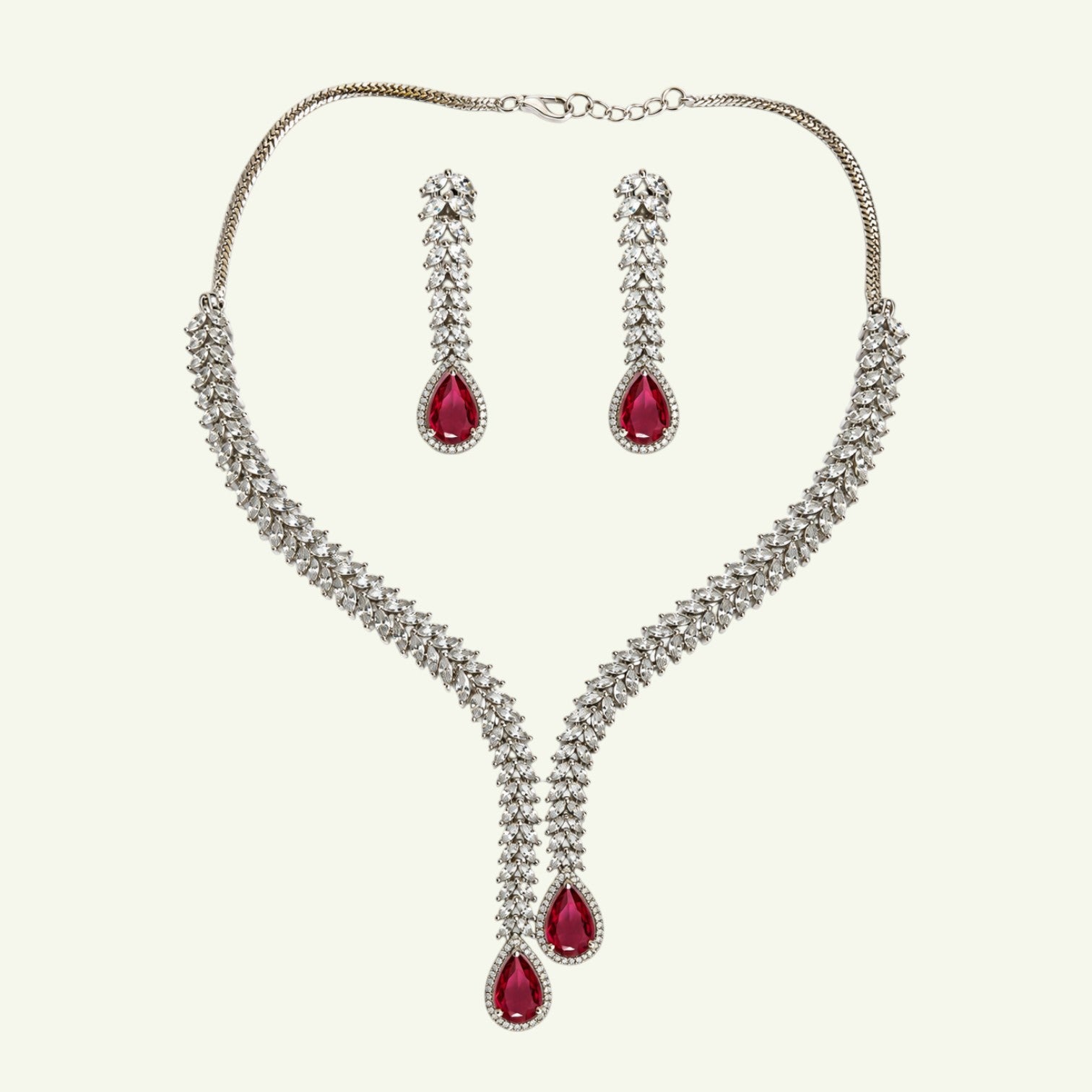 Anzora Jewel Alcyone necklace and earring set with clear crystals and ruby-red pear-cut stones in a V-shaped design.