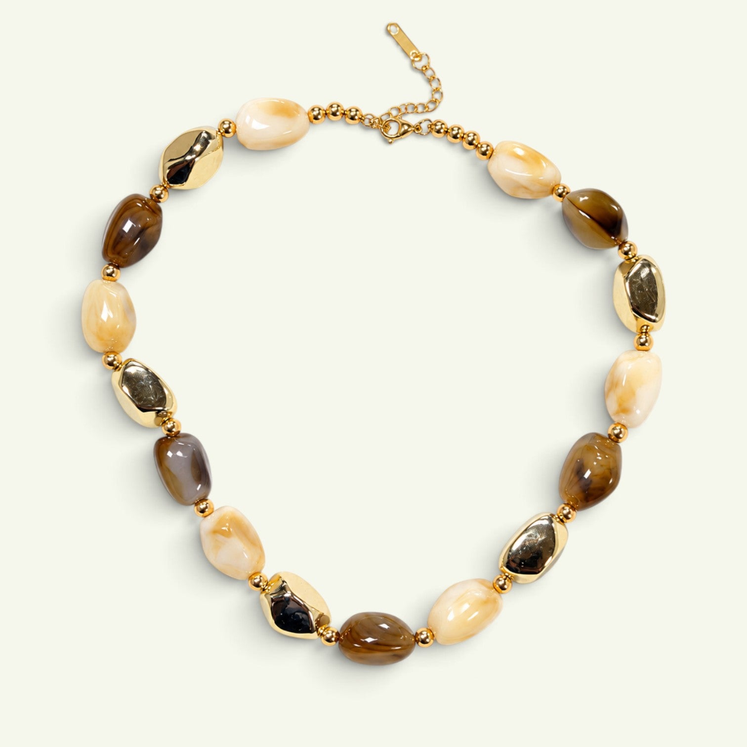 Anzora Jewel Amber & Alloy necklace with amber-brown beads, creamy neutral stones, and polished gold-tone accents.