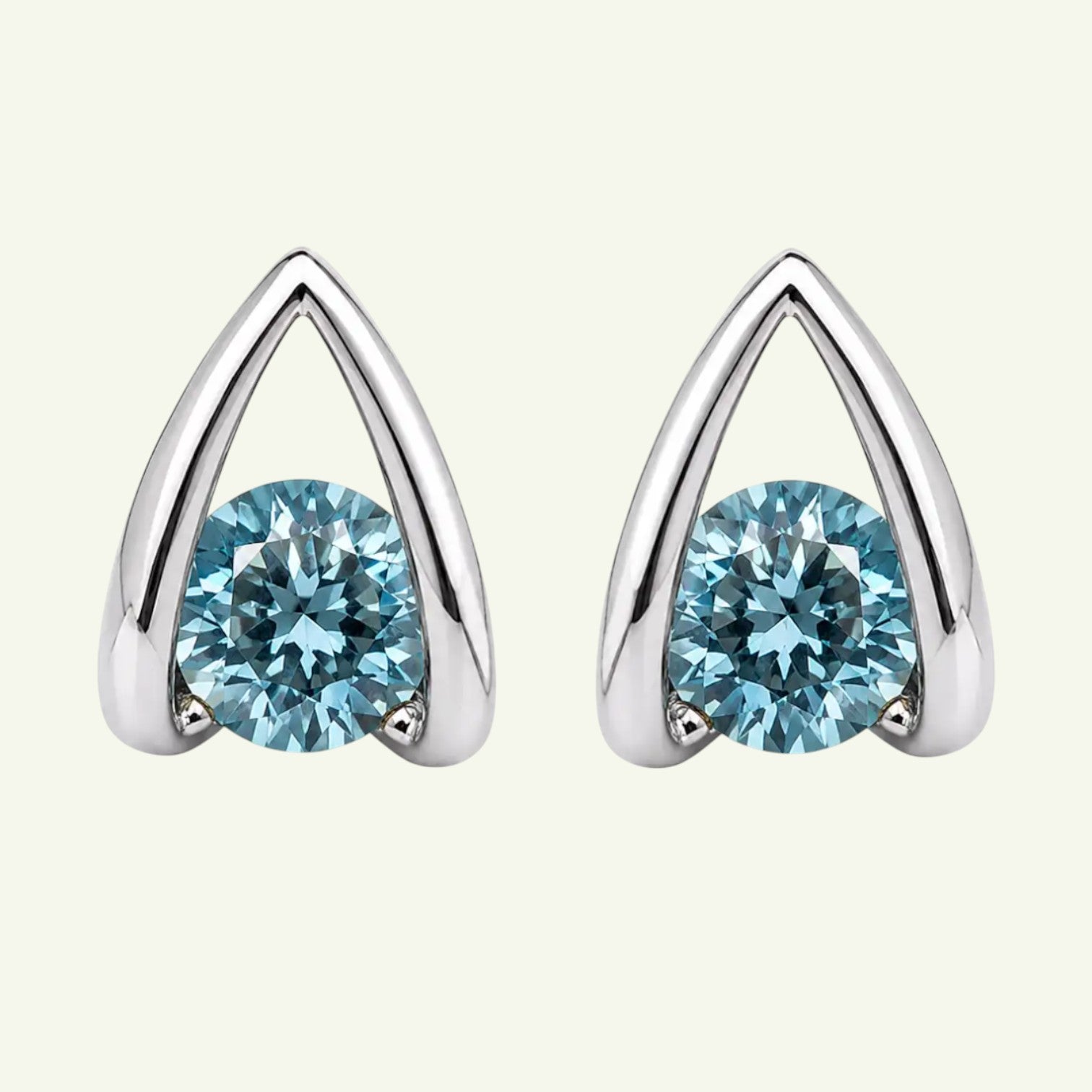 Anzora Jewel Astra Blue stud earrings featuring round-cut ocean-blue stones in a polished architectural silver frame.