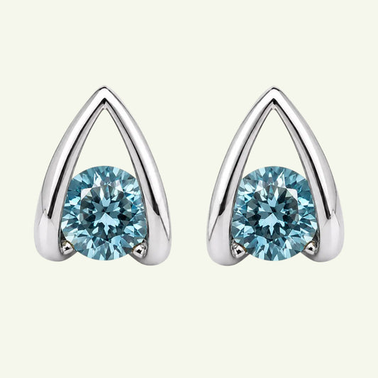 Anzora Jewel Astra Blue stud earrings featuring round-cut ocean-blue stones in a polished architectural silver frame.