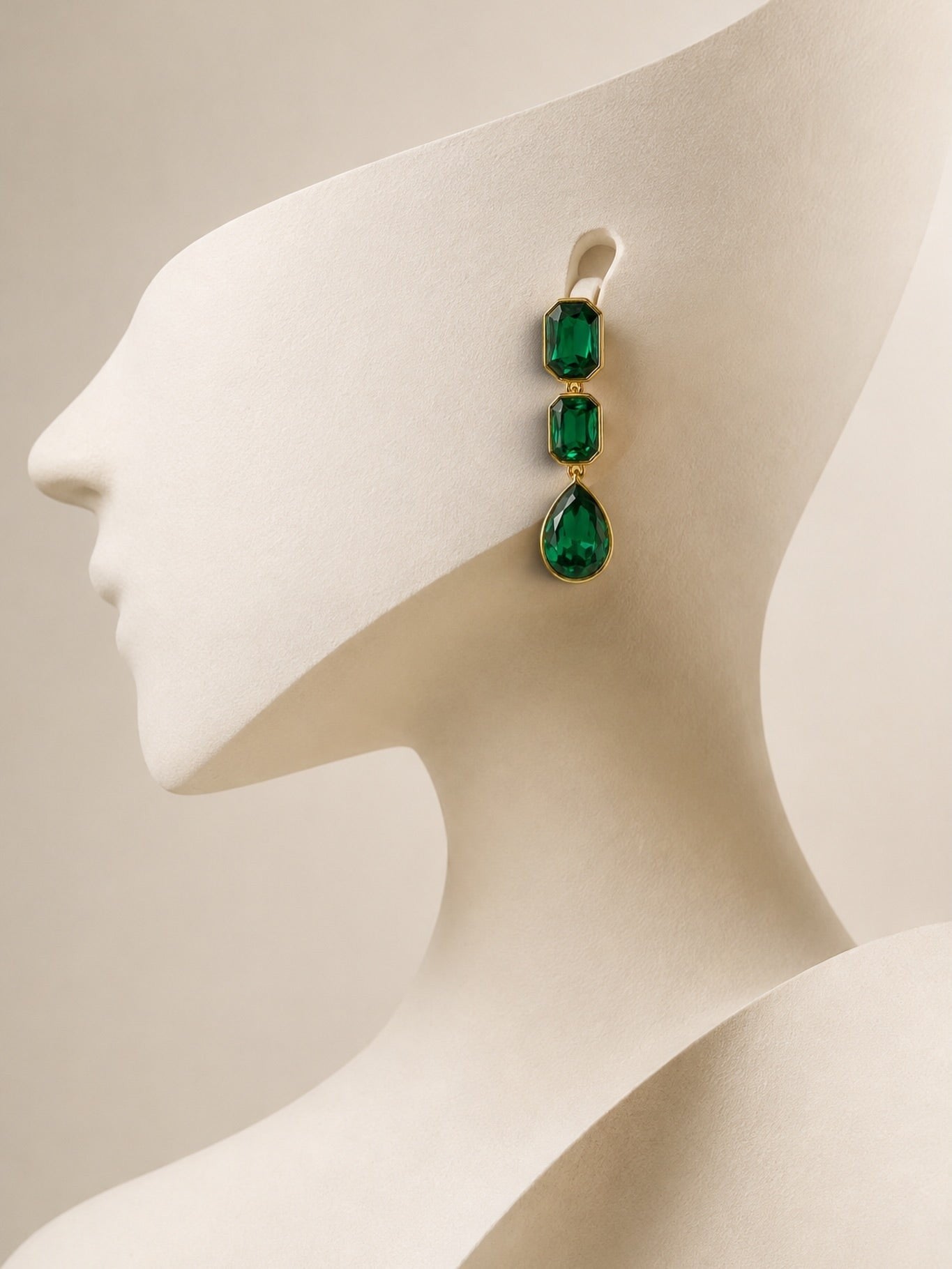 Anzora Jewel emerald green crystal drop earrings with three faceted stones in gold bezel settings on a mannequin.