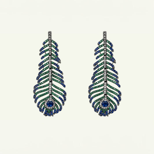 Anzora Jewel Featheris drop earrings featuring sapphire-blue, emerald-green, and clear stones on a gunmetal frame.