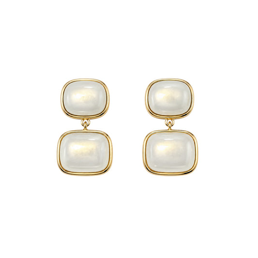 Anzora Jewel Noctis drop earrings featuring stacked cushion-cut milky cabochon stones in gold-tone bezel settings.