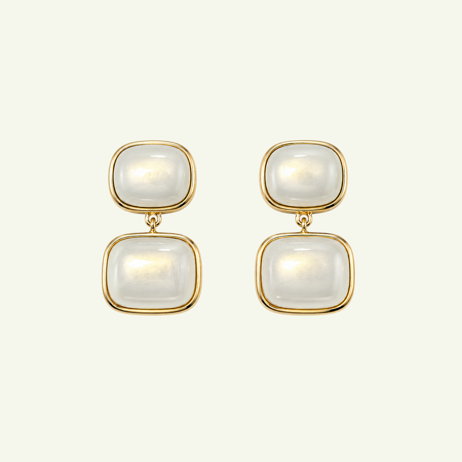 Anzora Jewel Noctis drop earrings featuring stacked cushion-cut milky cabochon stones in polished gold-tone bezels.