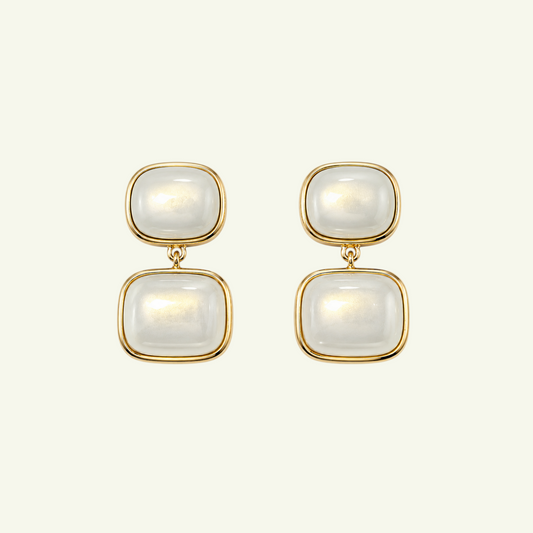 Anzora Jewel Noctis drop earrings featuring stacked cushion-cut milky cabochon stones in polished gold-tone bezels.