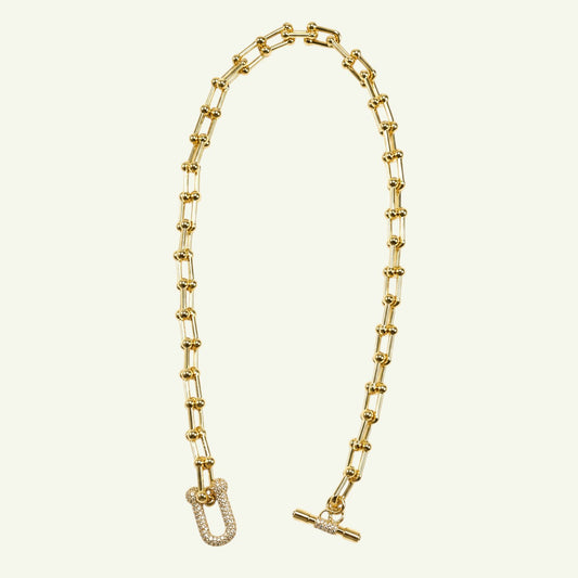 Anzora Jewel Nova Necklace featuring a gold gauge link chain with bead accents and a crystal-encrusted U-shaped link.
