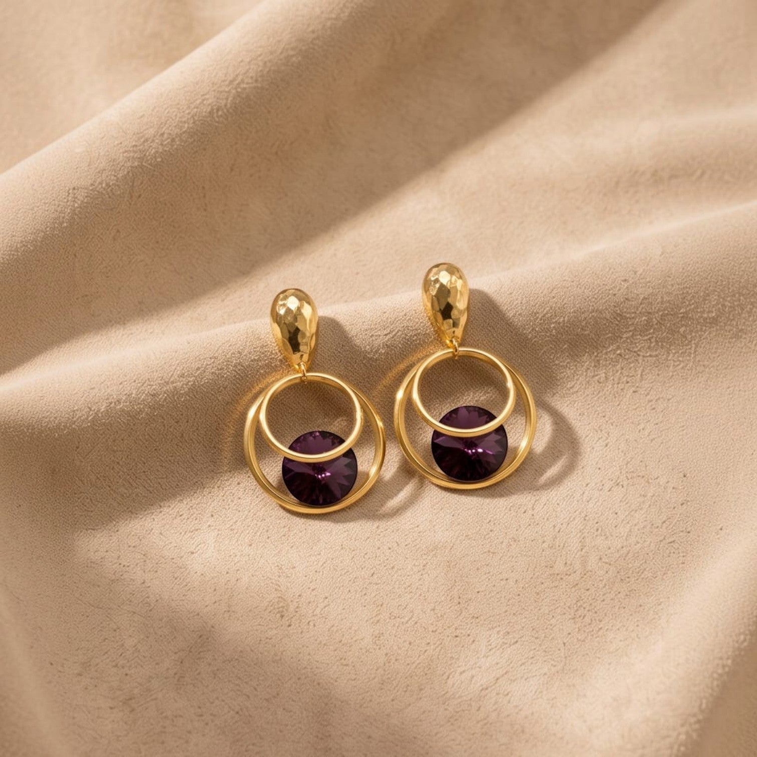Anzora Jewel Orbit statement earrings featuring hammered gold studs, double hoops, and deep purple faceted crystals.