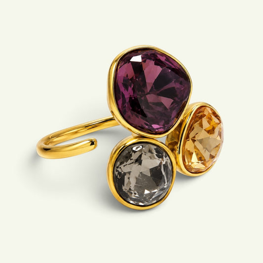 Anzora Jewel Trilogy cluster ring featuring faceted plum, smoky grey, and amber stones in a polished gold-tone setting.